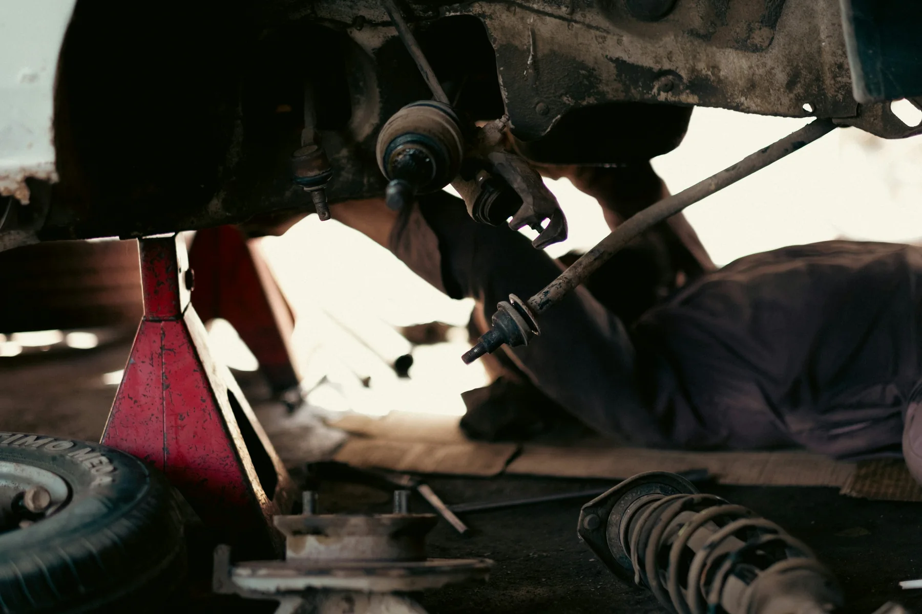 Mechaniker arbeitet an der Unterseite eines Fahrzeugs